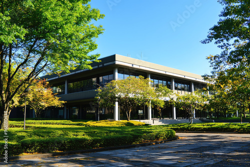 A modern government office building surrounded by lush trees and greenery