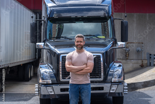 Truck driver. CDL. Portrait of trucker standing by his truck vehicle ready for transport. Male driver standing in front on his truck. Men driver near lorry trucks. Man owner truck driver. Millennial photo