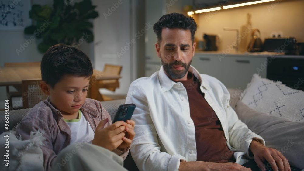 Obraz premium Man boy browsing internet at evening sofa closeup. Single father typing laptop