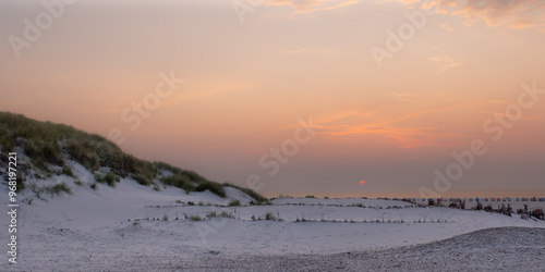 Stimmungsvoller Sonnenuntergang auf der Insel Amrum mit Dünen und Meer