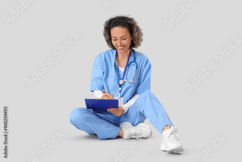 Mature female doctor writin...