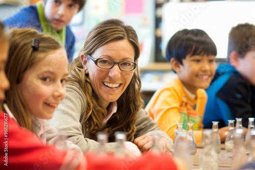 A woman with glasses is smiling at the camera in a classroom