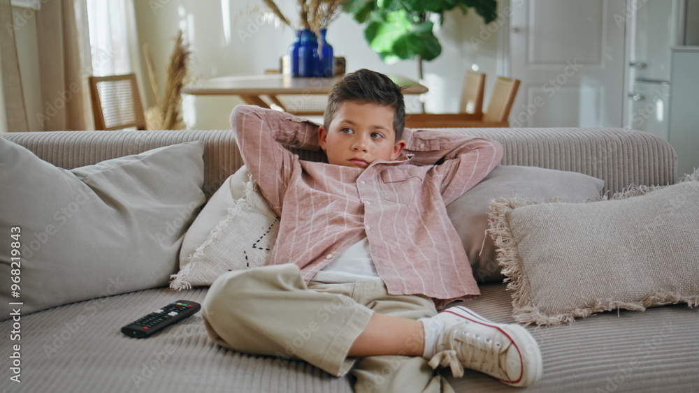 Little boy watching cartoons on tv sitting couch at living room. Kid resting Little boy watching cartoons on tv sitting couch at living room. Kid resting