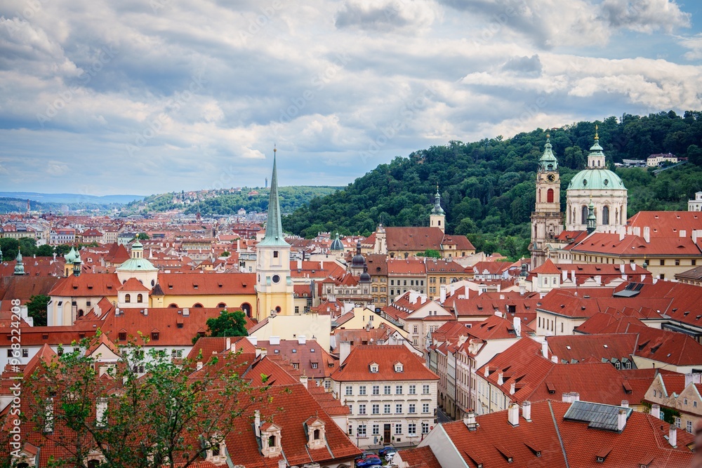 This stunning cityscape of Prague showcases charming red-roofed buildings and historic churches, capturing the essence of the citys architectural beauty against a captivating cloudy sky. This stunning cityscape of Prague showcases charming red-roofed buildings and historic churches, capturing the essence of the citys architectural beauty against a captivating cloudy sky.