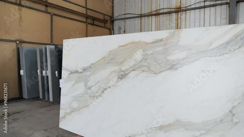 Colorful quartz and porcelain tile stone slab are standing in the factory warehouse. Kitchens and bathrooms countertop selection. Granite slabs are prepared for sale in store yard