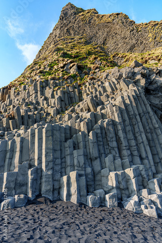 The dramatic Reynisfjara Beach features black volcanic sands and towering basalt sea stacks rising from the wild Atlantic Ocean in Iceland