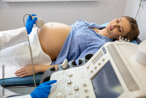 Pregnant woman lying on a couch in clinic while ultrasonography