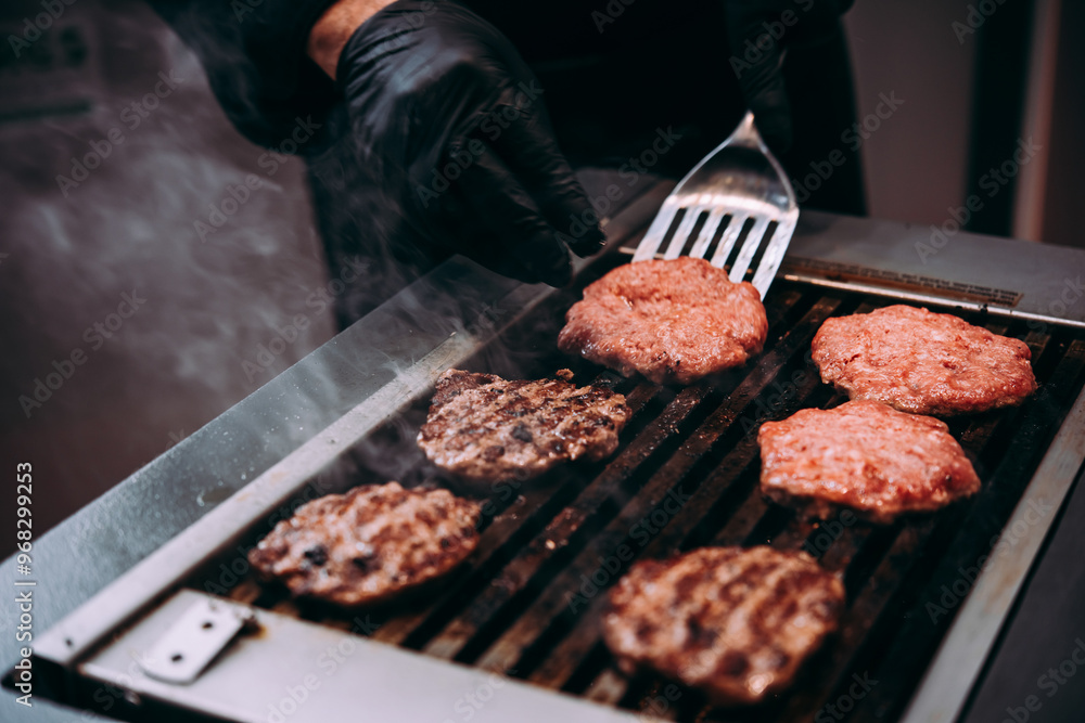 Grilling meat patties for classic burger in a cafe of a restaurant.