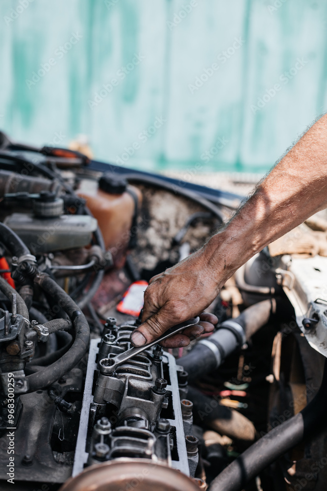 A worker repairs the cylinder head of an automobile engine. Oil removal valve. Car repairs. Car service A worker repairs the cylinder head of an automobile engine. Oil removal valve. Car repairs. Car service