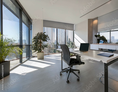 A clean, minimalist office space with sleek furniture, a large desk, and a laptop open, surr