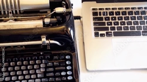 a vintage typewritter beside laptop concept of old and new technology photo