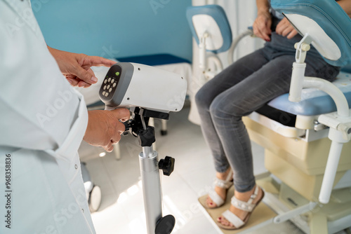 Woman at gynecologist preparing for colposcopy scan, sitting in the chair and taking pants off  photo