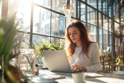 A young woman marketer works on her laptop in a sunlit, modern office, the scene exuding professionalism and creativity, styled like a high-end lifestyle magazine