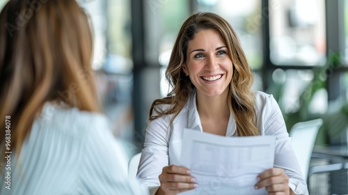 Fototapeta Naklejka Na Ścianę i Meble -  Smiling mature business woman hr holding cv document at job interview. Happy mid aged professional banking manager or lawyer consulting client sitting at workplace in corporate office meeting.