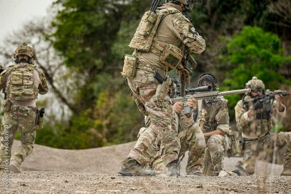 A group of military men in combat gear patrol in the middle of a desert and tropical jungle. Soldiers in full combat gear in dry weather conditions assemble and march on a mission. A group of military men in combat gear patrol in the middle of a desert and tropical jungle. Soldiers in full combat gear in dry weather conditions assemble and march on a mission.