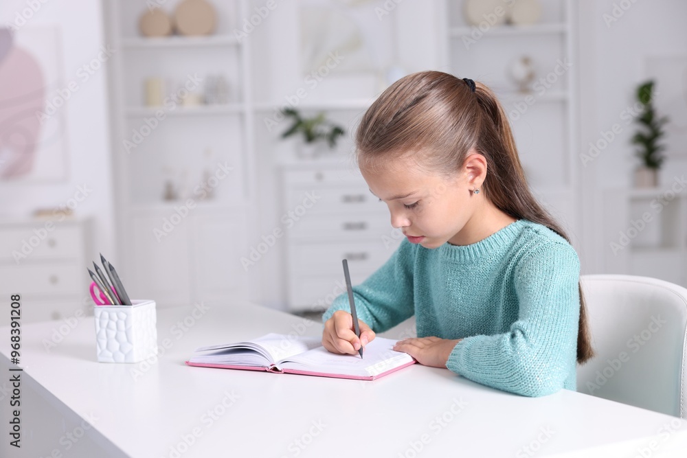Girl with correct posture doing homework at white desk indoors Girl with correct posture doing homework at white desk indoors