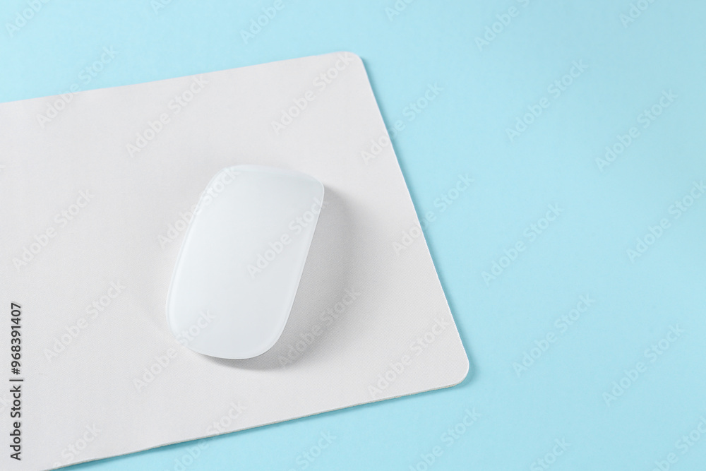 Wireless mouse and mousepad on light blue background, space for text Wireless mouse and mousepad on light blue background, space for text