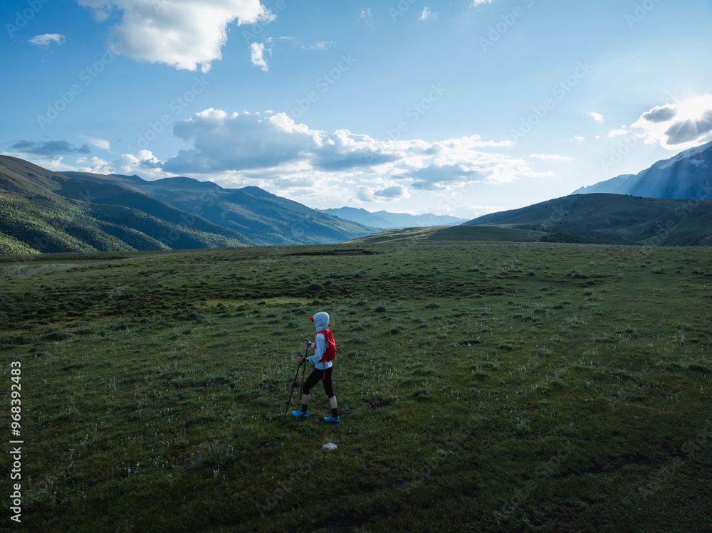 Fototapeta premium Aerial view of woman trail runner in high altitude mountains