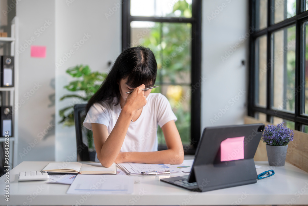Young asian accountant woman feeling stressed and tired while working with laptop computer Young asian accountant woman feeling stressed and tired while working with laptop computer