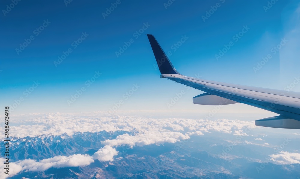 Airplane Wing Over Snowy Mountain Range and Clouds Airplane Wing Over Snowy Mountain Range and Clouds