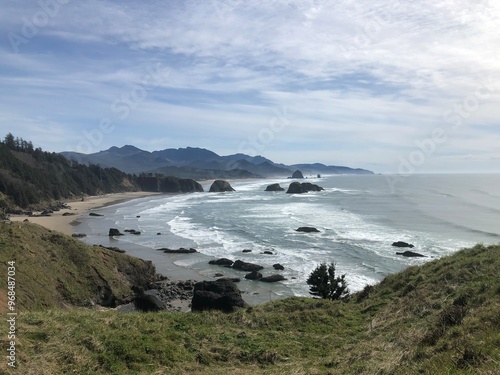 View of the pacific ocean along the Oregon coast with mountains in the background, taken from Ecola State Park in Oregon