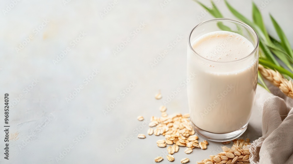 Delicious oat milk in a glass, surrounded by fresh oats and green leaves, perfect for healthy and vegan lifestyles. Delicious oat milk in a glass, surrounded by fresh oats and green leaves, perfect for healthy and vegan lifestyles.