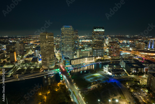 View from above of brightly illuminated high skyscraper buildings and moving traffic in downtown district of Tampa city in Florida, USA. American megapolis with business financial district at night photo