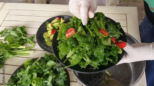 Food processing from fresh raw ingredient for healthy eating, mix salad with vegetable dressing, avacado, baby spinach, crytal letture, cherry tomato, vegetarian vibrant meal photo