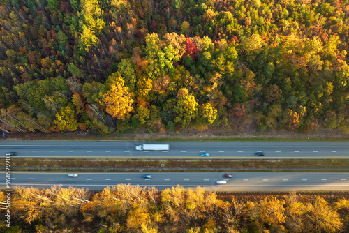 Wide multilane highway road in USA Appalachian mountains with fast driving semi trucks. Above view of American transportation infrastructure photo