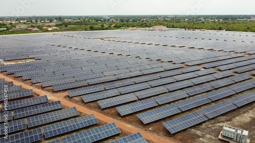 Slightly dirty solar panels at African industrial solar photovoltaic farm in rural area with greenery photo