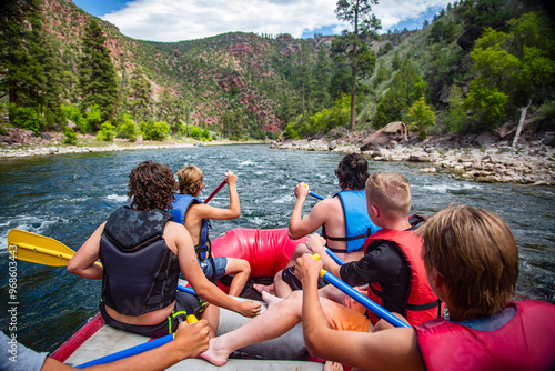 A large group of men and boys on a white water rafting trip down the Colorado River. View from behind of as they seek adventure and fun. photo