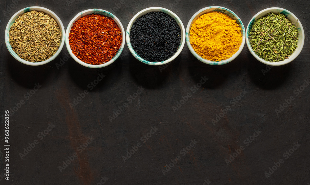 Traditional oriental spices in ceramic bowls. black cumin seed, ground red pepper, dried mint, himalayan salt. Traditional oriental spices in ceramic bowls. black cumin seed, ground red pepper, dried mint, himalayan salt.
