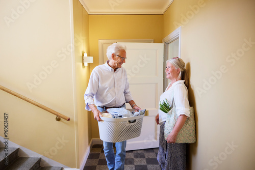 Smiling male and female residents talking with each other in building corridor photo