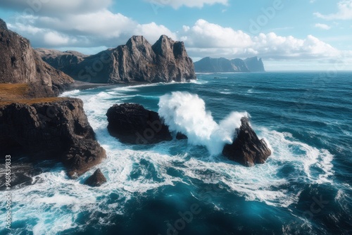 A rocky coastline where powerful waves crash against rugged cliffs, creating dramatic splashes and foamy whitecaps. photo