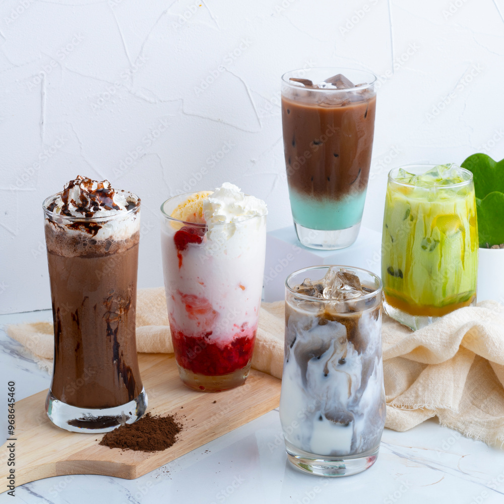 Assorted iced beverages, including coffee, latte, and fruity drinks, served in clear glasses with whipped cream and toppings. Assorted iced beverages, including coffee, latte, and fruity drinks, served in clear glasses with whipped cream and toppings.