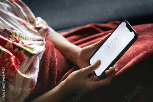 Close-up of woman scanning her thumbprint on mobile phone photo