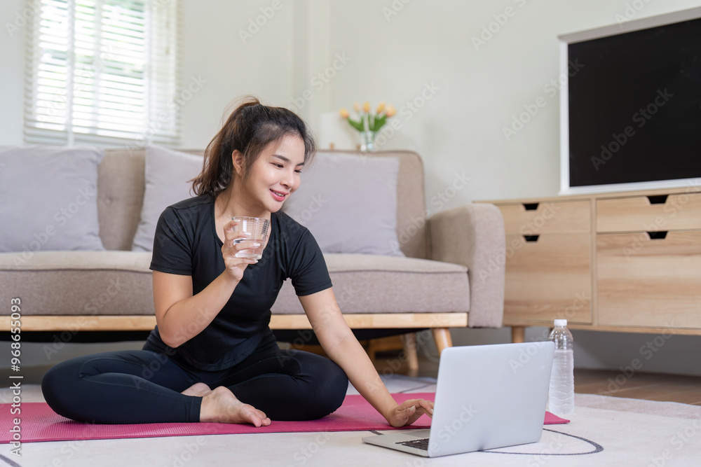 Woman enjoying yoga session with water break at home Woman enjoying yoga session with water break at home