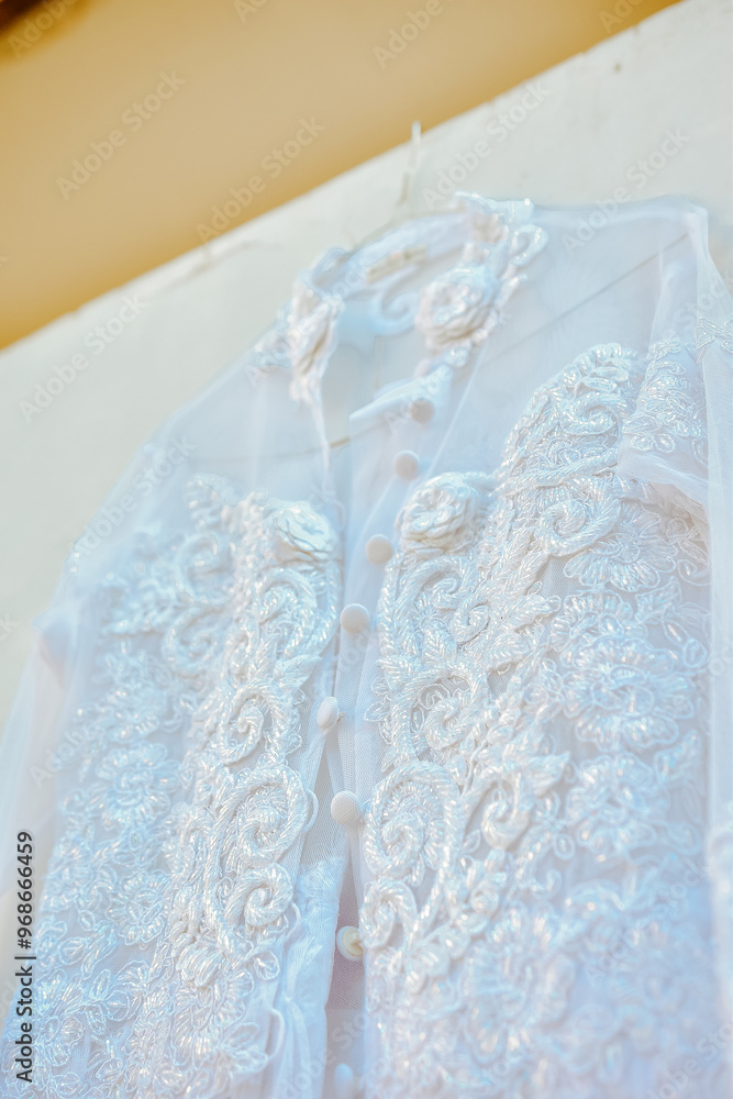 Wedding dress hanging on white wall Wedding dress hanging on white wall