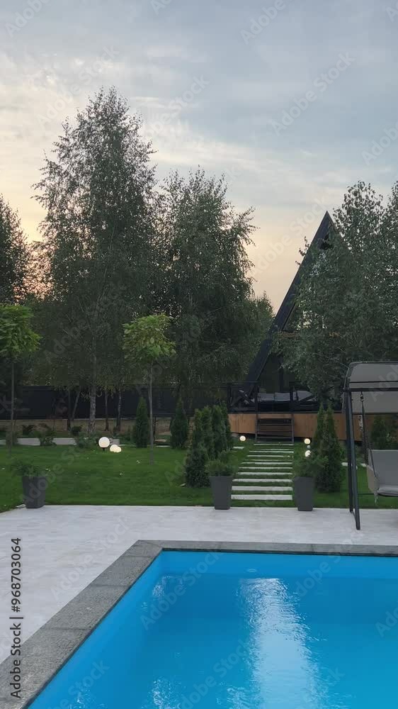 A-frame House. Modern new frame country house standing in a mixed forest in front of the camera against the backdrop of trees. A-frame House. Modern new frame country house standing in a mixed forest in front of the camera against the backdrop of trees.