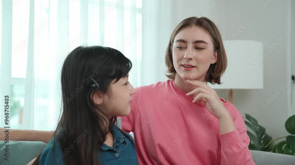 Caucasian mother telling her story to cute daughter while girl listening the fairytail. Happy mom tell and exchange experience to young student while happy attractive child sitting at sofa. Pedagogy. Caucasian mother telling her story to cute daughter while girl listening the fairytail. Happy mom tell and exchange experience to young student while happy attractive child sitting at sofa. Pedagogy.