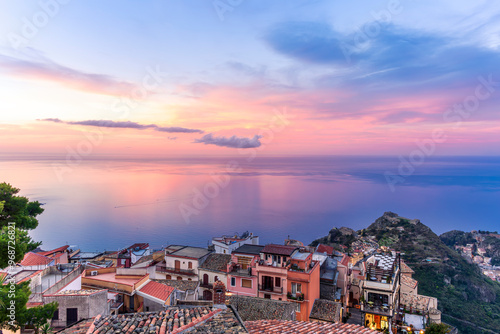 sceniv view from a high mountain town to amazing landscape of sea coast, roofs in vintage style of Italy and beautiful colorful sunset or sunrise cloudy sky