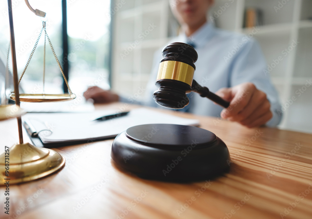 Lawyer Holding Gavel with Scales of Justice on Desk Lawyer Holding Gavel with Scales of Justice on Desk