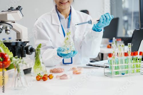 Two female researchers in the lab work at a desk on plant genetic modification for food, meat, and vegetables, utilizing advanced genetic engineering technology to enhance crops and animal feed.