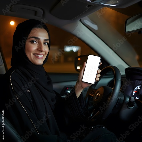 Woman Driving at Night in a Black Abaya, Smiling and Holding a Phone with a Blank Screen