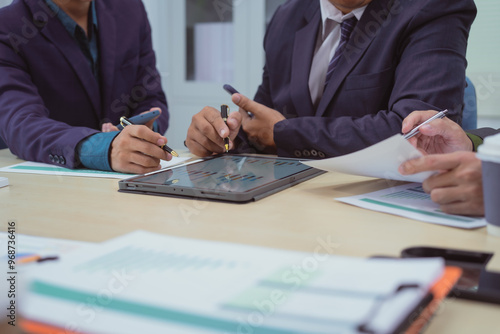  Close-up of a businessman in a meeting with a group of businessmen in the office, discussing digital marketing strategies, financial data analysis, and planning business projects together.