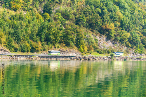 Tour buses along the lake with green forest in the background and beautiful water reflection of the forest. Lucerne, Switzerland, 19 Aug 2022 photo