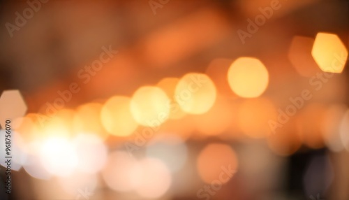 City street at night, with blurred lights reflecting on a wet pavement. Blurred background with soft warm-toned bokeh-light 