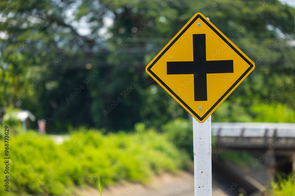 Intersection yellow traffic sign, Four cross road ahead warning, Road sign badge beware of an intersection slow speed car. Intersection yellow traffic sign, Four cross road ahead warning, Road sign badge beware of an intersection slow speed car.