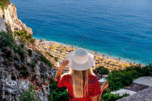 The girl in white hat and red dress watches panoramic  Kaputas Beach, Kas Antalya Turkey photo