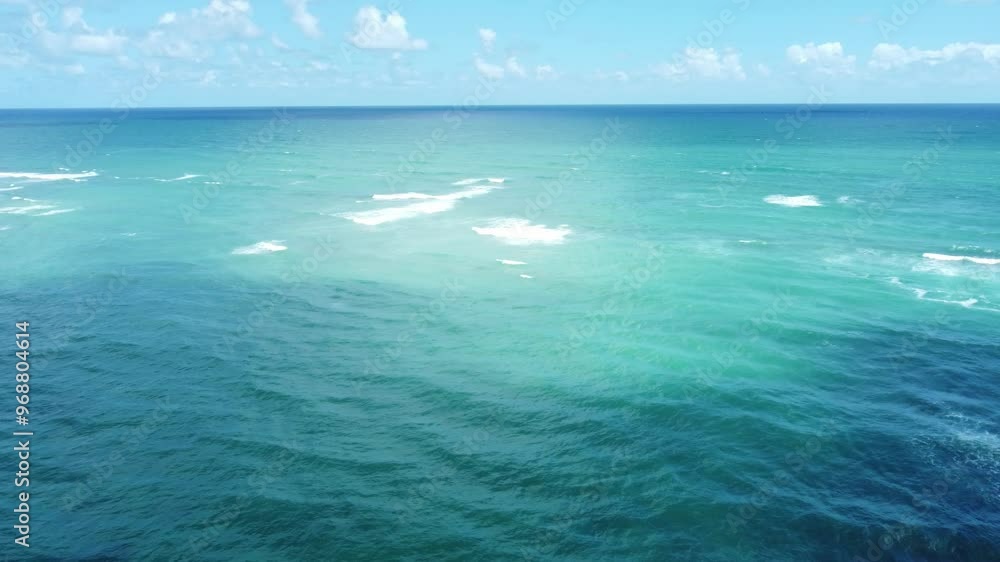 The drone’s aerial view of Oahu’s ocean reveals the stunning clarity of the Pacific waters, with waves gently rolling toward the shore and the vibrant blue hues stretching to the horizon. The drone’s aerial view of Oahu’s ocean reveals the stunning clarity of the Pacific waters, with waves gently rolling toward the shore and the vibrant blue hues stretching to the horizon.